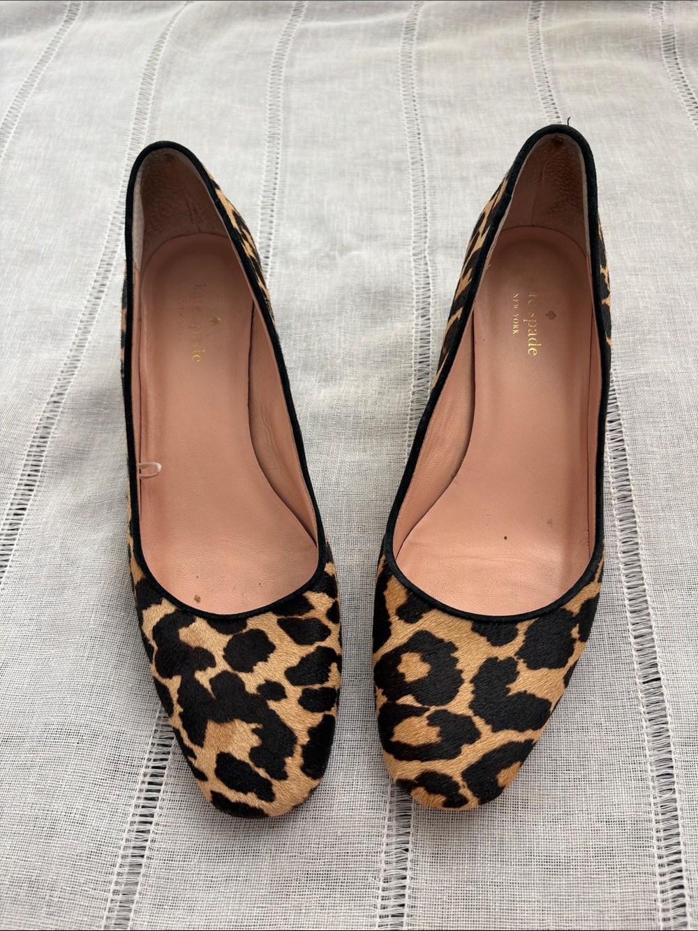 Kate Spade leopard print calf hair heels with brown trim and tan insoles.